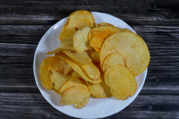 Potato chips, crisps, thin slices of potato,  deep fried, baked, or air fried until crunchy, served as a snack, side dish, or appetizer, basic chips are cooked and salted, some with other flavors