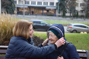 Two elderly ladies, mother and daughter, walking around the city, talking, laughing, drinking coffee. Active healthy lifestyle