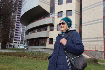 Portrait of an active elderly lady 89 years old on a walk in the city