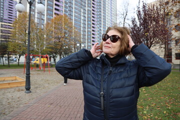 Portrait of an active elderly lady 70 years old on a walk in the city