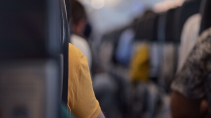 View through aisle between seats in airplane passenger cabin