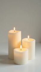 softly lit white candles against bright backdrop, brightness, soft glow, still life