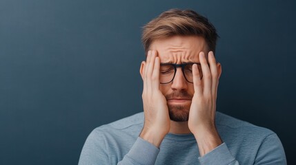 Young man feeling stressed and frustrated while holding his head in a relaxed indoor environment