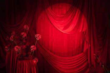 Heart shaped floral arrangements of roses and anthuriums against a red curtain and draperies....