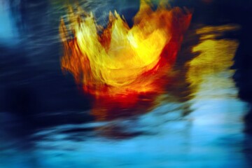 Obraz premium Abstract vibrant flame emerging from water surface with blurred motion in colorful artistic visual representation of passion and energy in nature