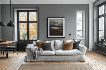 Cozy scandinavian living room with white sofa and fall views through large windows