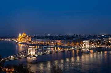 View of Danube River, the Szechenyi Chain Bridge and Parliament of Hungary illuminated at night