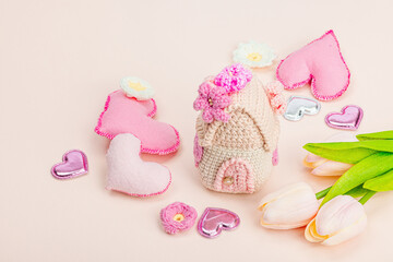 Handmade Valentines Day concept. Creative spring crocheting, house figurine, flowers and hearts