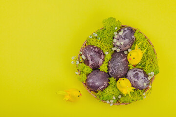 Marble Easter eggs, wooden basket, moss, gypsophila flowers. Festive concept, greeting card