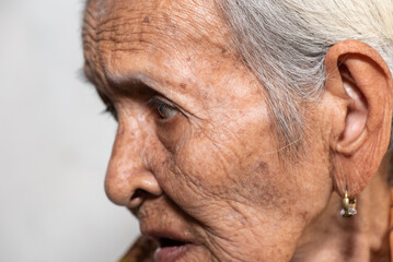 Fototapeta premium Lonely senior woman portrait sad depressed,emotion, feelings, thoughtful, senior, old woman,wait, gloomy, worried, covering her face, Human face expressions 
