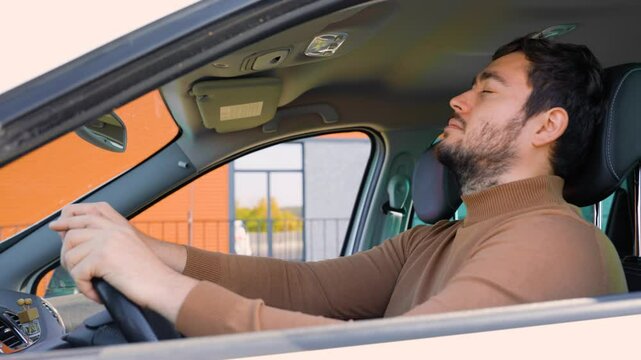 A very tired man behind the wheel does not want to go home and is resting in the car.