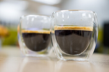 Hot black coffee in double walled glass. Close up