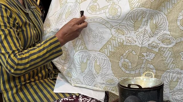 Asian woman painting Batik Tulis.