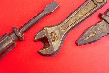 Old rusty pliers isolated on a red background.