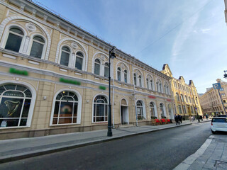 historical pink building with multiple floors, adorned with decorative features and air conditioning units on its windows. The combination of classic design and modern amenities highlights urban