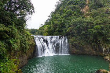 Fototapeta premium Lush green surroundings of Taiwan Shifen waterfall