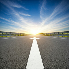 road in the sunset. low angle of white arrow on road showing goal. low angle empty road with white arrow.
