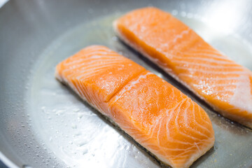 Fresh salmon fillets cooking on hot pan