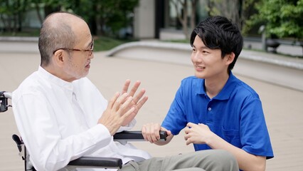 Obraz premium 車椅子の高齢者と話をする介護士