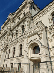 Fototapeta premium A grand facade featuring intricate carvings, tall arched windows, and contemporary railings. The composition emphasizes the harmony of traditional craftsmanship and modern infrastructure.