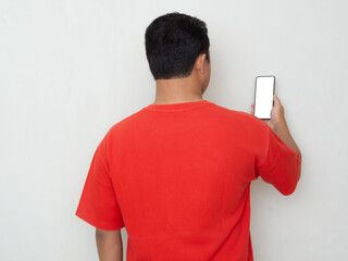 Back view of a man with red shirt looking to the mobile phone that he hold