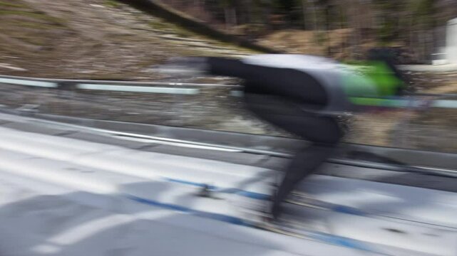 Ski jumper running down the ski jumping hill, flying and landing on a landing slope, handheld shot. Winter sports venue concept.