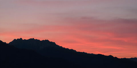 Obraz premium A silhouette of mountains at dusk with hues of pink, orange, and purple, 8K clarity.