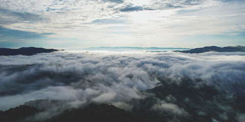 Obraz premium Aerial landscape view of the sea of fog flowing on hills by drone
