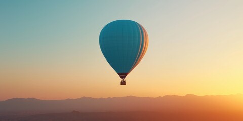 Fototapeta premium A beautiful sunrise landscape with a blue hot air balloon in the sky