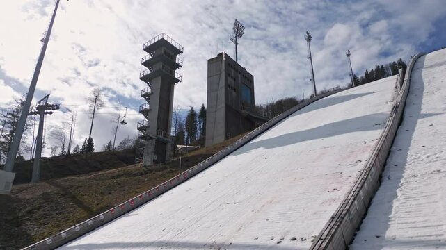 Jumper during training on ski jump Planica, a popular winter sports area in Slovenia with a chairlift near Kranjska Gora, drone shot.