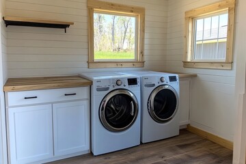 Laundry room with two washing machines, wood counters, and white walls