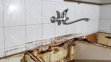 Close-up of a rusted and dirty kitchen sink highlighting neglect and cleanliness issues, ideal for home maintenance concepts