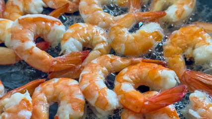 Close-up of sizzling shrimp frying in oil, ideal for seafood cuisine concepts or summer barbecue holiday themes