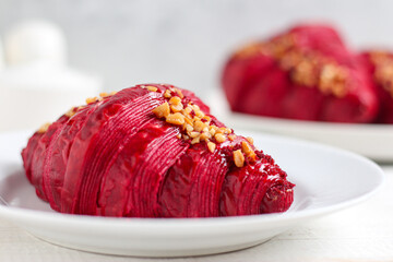 Red velvet croissant on a white plate.
