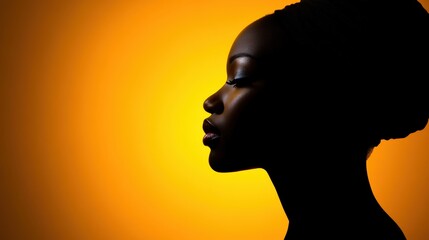 Silhouette of african female profile against vibrant orange background