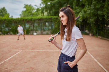 Confident female tennis player posing outdoors