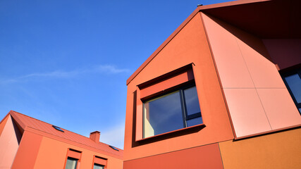 Terraced family homes in newly developed housing estate. The real estate market in the suburbs. New single family houses in a new development area. Residential homes with modern facade. 