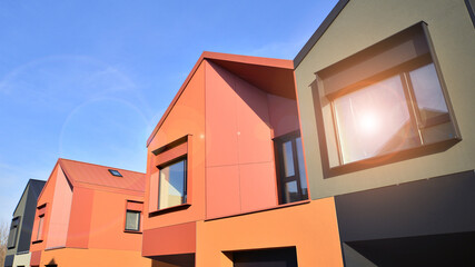 Terraced family homes in newly developed housing estate. The real estate market in the suburbs. New single family houses in a new development area. Residential homes with modern facade. 