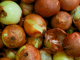 pile of fresh, golden brown onions, highlighting their layered texture and earthy aroma. Perfect for food photography