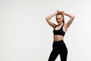 Sporty slim woman with ponytail fitness woman enjoys workout exercise in purple sport wear on white background