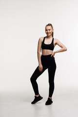 Obraz premium Smiling fit woman in fitness outfit isolated on white background with copy space.