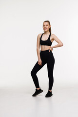 Obraz premium Smiling fit woman in fitness outfit isolated on white background with copy space.