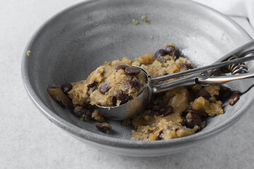 Overhead view of chocolate chip cookie dough, top view of homemade chocolate chip cookie dough in a bowl on a white background, process of making chocolate chip cookies
