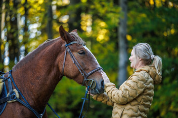 Woman with her horse outdoors. Friendship between people and animal
