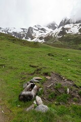 Rustic Wooden Water Trough in Alpine Meadow with Snow-Capped Peaks, Zillertal, Tirol, Austria