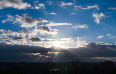 Sun rays break through the clouds. Sunset. Beautiful blue sunset sky with clouds. Natural background. Selective focus.