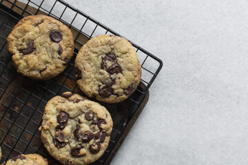 Overhead view of chocolate chip cookies on a cooling rack, top view of homemade chocolate chip cookies on a white background