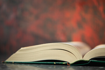An open book lying on the countertop, with a red blurry wall in the background. Space for text, design.