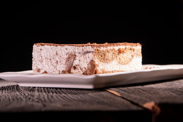 Tiramisu cake dessert served with coffee, biscuit and cocoa on dark background.spoon. Dessert. Food Concept