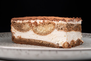 Tiramisu cake dessert served with coffee, biscuit and cocoa on dark background.spoon. Dessert. Food Concept